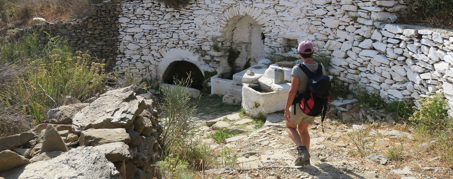 Walker near a stone fountain - Amorgos - Greece