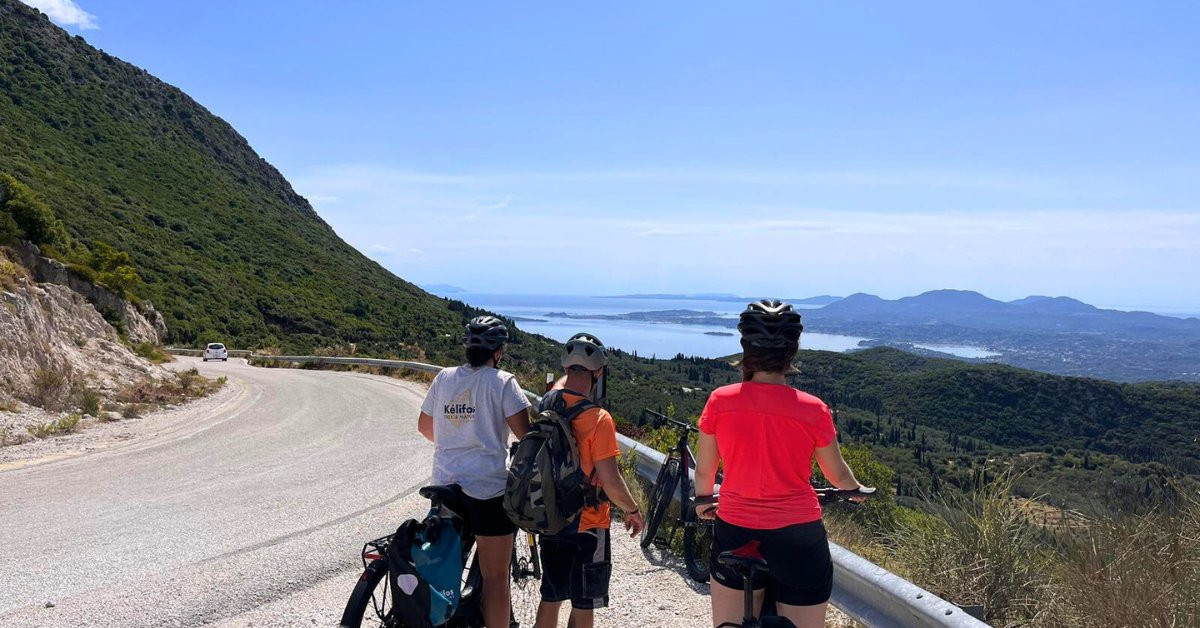 Cyclists overlooking a turquoise bay - Corfu - Greece
